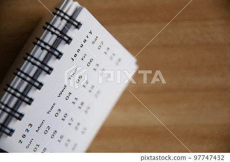 January 2023 white table calendar with wooden table background. Calendar 2023 concept. 97747432
