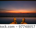 Close-up of legs in the swimming pool on the rooftop, sunset Close-up of legs in the swimming pool on the rooftop, sunset 97748057