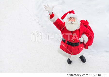 Top view of friendly santa claus waving hand outdoors in winter 97748198
