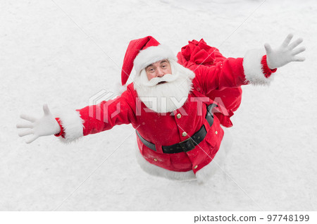 Top view of friendly santa claus waving hand outdoors in winter Top view of friendly santa claus waving hand outdoors in winter 97748199