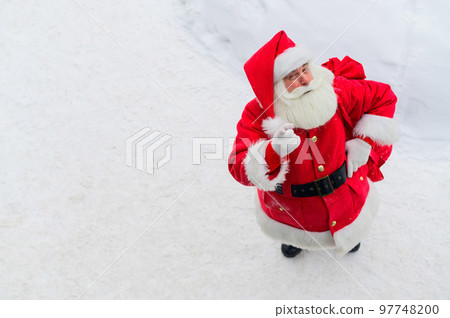 Top view of friendly santa claus waving hand outdoors in winter 97748200