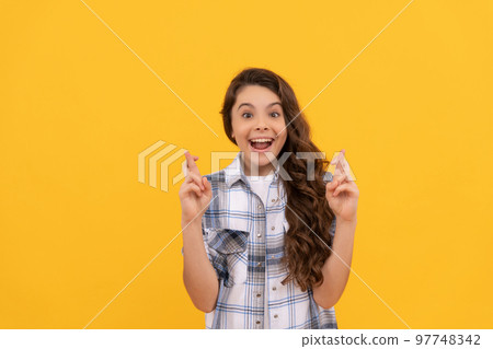 amazed teen child in checkered shirt cross fingers on yellow background 97748342