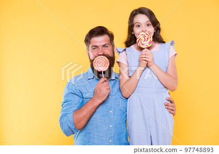 Sweet life. How to please your child and avoid problems. Sweet food. Girl child and dad hold lollipops. Sweet dessert. Loving daddy for daughter. Sweets and treats concept. Sugar diet. Health care 97748893