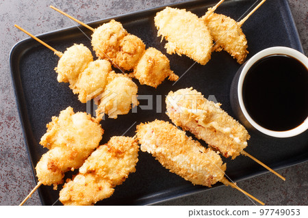 Japanese Kushikatsu Deep-fried vegetables, eggs and meat on skewer closeup on the plate. Horizontal top view Japanese Kushikatsu Deep-fried vegetables, eggs and meat on skewer closeup on the plate. Horizontal top view 97749053