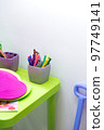 Children's table with pencils for drawing and toys in the nursery. Children's background is bright with copy space. Preschool education 97749141