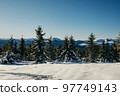 A man standing on top of a snow covered slope 97749143