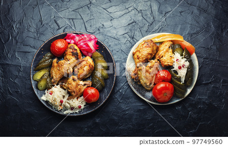 Tasty baked chicken and pickles. 97749560
