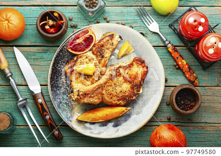 Pork steak roasted with citrus fruits. Pork steak roasted with citrus fruits. 97749580