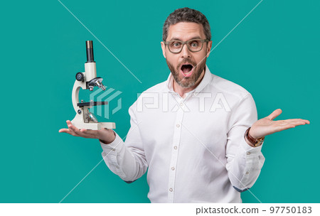 amazed man holding invention microscope in studio. man microscope for invention. amazed man holding invention microscope in studio. man microscope for invention. 97750183