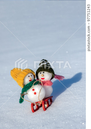 Snowmen playing sledding 97751243