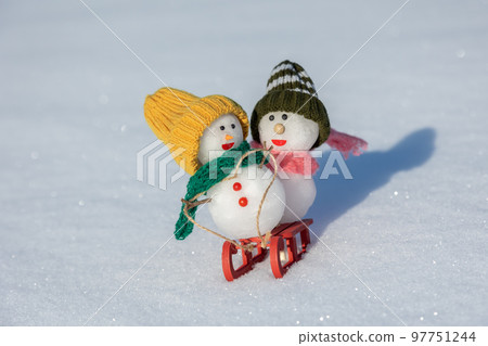 Snowmen playing sledding 97751244