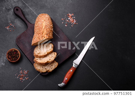 Delicious crispy bread with cereals cut into slices on a wooden cutting board Delicious crispy bread with cereals cut into slices on a wooden cutting board 97751301