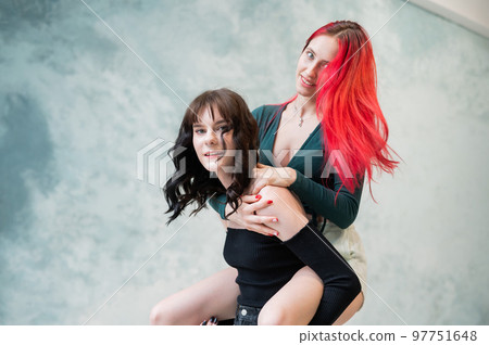 Two friends are fooling around. Young caucasian woman on the back of another.  97751648