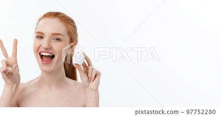 portrait of beautiful woman smiling while taking some facial cream isolated on white background with copy space. 97752280