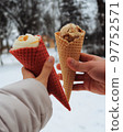 Ice cream in the hands on the background of snow in winter vertical photo 97752571