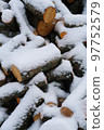 Stack of snow-covered firewood in winter vertical photo 97752579
