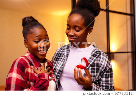 african american woman making proposal to her girlfriend while they have romantic evening date 97753112