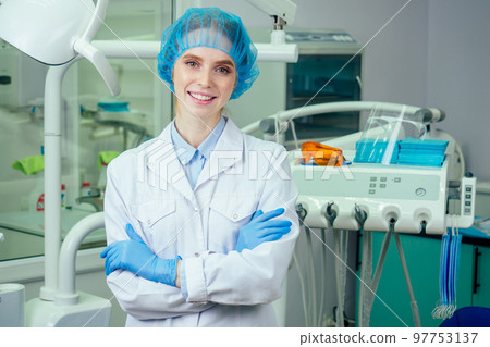 Young beautifu dentist at work in the office . she looking at camera with surgical lamp Young beautifu dentist at work in the office . she looking at camera with surgical lamp 97753137