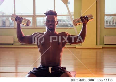 afro holding dumbbells workout for abc press and hands in gym windows background afro holding dumbbells workout for abc press and hands in gym windows background 97753140