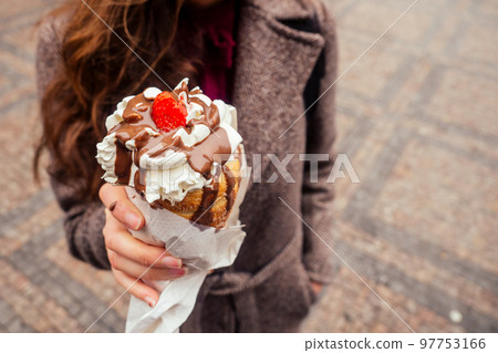 appetite eats a traditional Czech sweet Trdelnik with vanilla cream and strawberries in Prague street appetite eats a traditional Czech sweet Trdelnik with vanilla cream and strawberries in Prague street 97753166