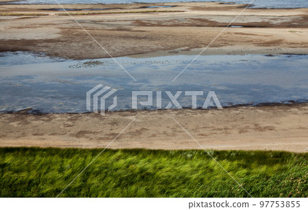 Water, sand and grass. Coastal landscape. Water, sand and grass. Coastal landscape. 97753855