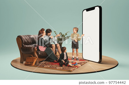 Young family, man, woman and kids sitting and looking on huge 3D model of phone screen. Online shopping. 97754442