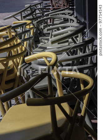 detail of Stack of Dark green (Khaki color) and Yellow plastic chairs. detail of Stack of Dark green (Khaki color) and Yellow plastic chairs. 97754543