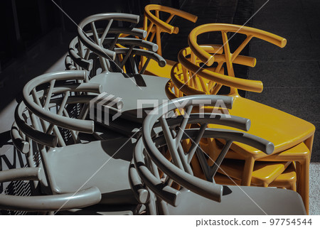 Detail of Stack of Dark green (Khaki color) and Yellow plastic chairs. Detail of Stack of Dark green (Khaki color) and Yellow plastic chairs. 97754544