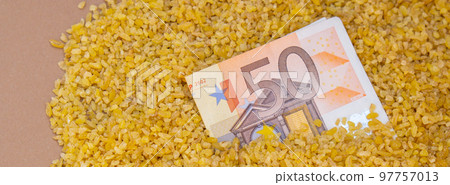 Euro bill paper money currency banknote in buckwheat porridge. The crisis in the market of grain crops, the rise in prices or production volumes of buckwheat Food and groceries shopping price increase Euro bill paper money currency banknote in buckwheat porridge. The crisis in the market of grain crops, the rise in prices or production volumes of buckwheat Food and groceries shopping price increase 97757013
