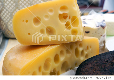 Traditional Hard Cheese Emmental with many Holes in it at the Food Market. 97757146
