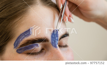 Eyebrow correction. The master removes excess hairs with wax and tweezers. Eyebrow correction. The master removes excess hairs with wax and tweezers. 97757152