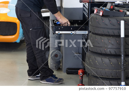 A man car mechanic takes tools out of a drawer A man car mechanic takes tools out of a drawer 97757910