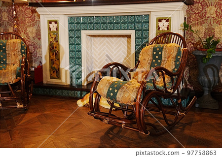 rocking chairs by the fireplace. interior in retro style. rocking chairs by the fireplace. interior in retro style. 97758863
