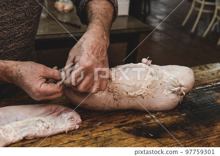 Hands making homemade head cheese, Patagonia, Argentina 97759301