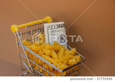 Shopping trolley cart Filled With Pasta with 20 US dollar paper money banknote on Beige background. Copy space for your text. Food and groceries shopping price increase, Rising food cost food crisis Shopping trolley cart Filled With Pasta with 20 US dollar paper money banknote on Beige background. Copy space for your text. Food and groceries shopping price increase, Rising food cost food crisis 97759389