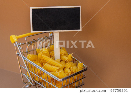 Empty mockup template Blackboard label against Shopping trolley cart Filled With Pasta on Beige background. Copy space for your text. Food and groceries shopping price increase, Rising food cost food Empty mockup template Blackboard label against Shopping trolley cart Filled With Pasta on Beige background. Copy space for your text. Food and groceries shopping price increase, Rising food cost food 97759391