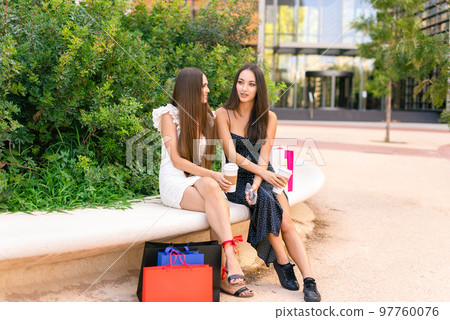Trendy ladies with coffee and shopping bags Trendy ladies with coffee and shopping bags 97760076