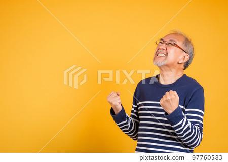 Happy Asian elder man with glasses excited say yes gesture like winner studio shot isolated on yellow background, Portrait smiling senior old man lifestyle he arms raised to celebrating his success Happy Asian elder man with glasses excited say yes gesture like winner studio shot isolated on yellow background, Portrait smiling senior old man lifestyle he arms raised to celebrating his success 97760583