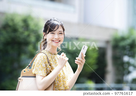 Smartphone, young woman, search, research, smile, looking at the camera 97761617