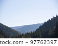Forested mountain and clear blue sky 97762397
