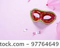 Table top view aerial image of beautiful colorful carnival festival background.Flat lay accessory object the several mask  decor confetti on modern pink paper at home office desk studio.copy space.. 97764649