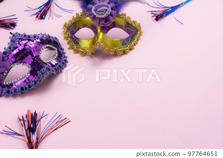Table top view aerial image of beautiful colorful carnival festival background.Flat lay accessory object the several mask  decor confetti on modern pink paper at home office desk studio.copy space.. 97764651