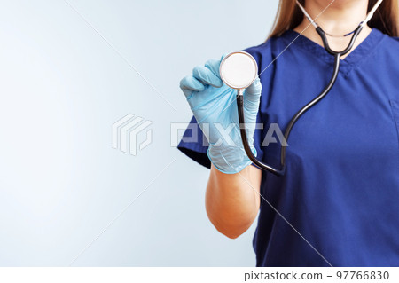 Female doctor in uniform with stethoscope on a blue background Female doctor in uniform with stethoscope on a blue background 97766830