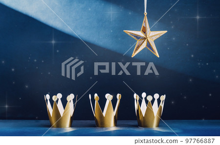three shiny golden paper crowns and a star in the blue sky. Epiphany and three kings day holiday celebration night banner. 6 January. Light trails. Christian tradition three shiny golden paper crowns and a star in the blue sky. Epiphany and three kings day holiday celebration night banner. 6 January. Light trails. Christian tradition 97766887