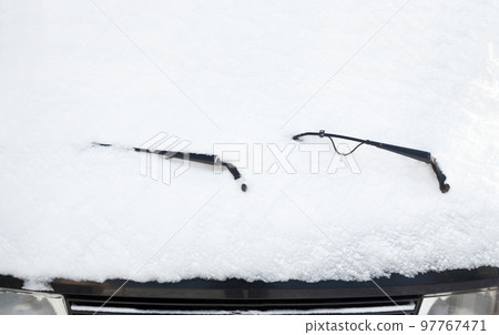 Car wipers and windscreen covered with snow 97767471