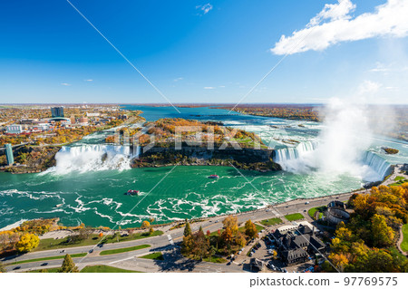 Niagara Falls American Falls and Horseshoe Falls in a sunny day in autumn foliage season. Niagara City Cruise Boat Tour. 97769575