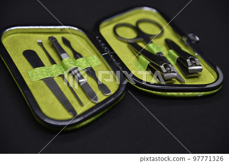 Green manicure set on a black background. Scissors and forceps for hand care. 97771326