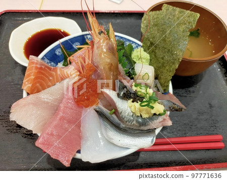 Bowl of rice topped with sashimi  97771636