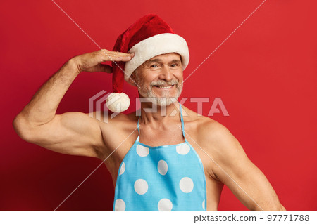 Honest Grandfather Posing Studio. Bearded Man In Santa Hat And Apron Honest Grandfather Posing Studio. Bearded Man In Santa Hat And Apron 97771788