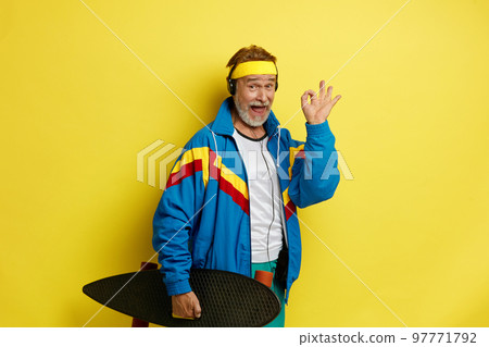 Smiling Man Holding Skateboard. Headphones Senior Man Showing Ok Gesture 97771792